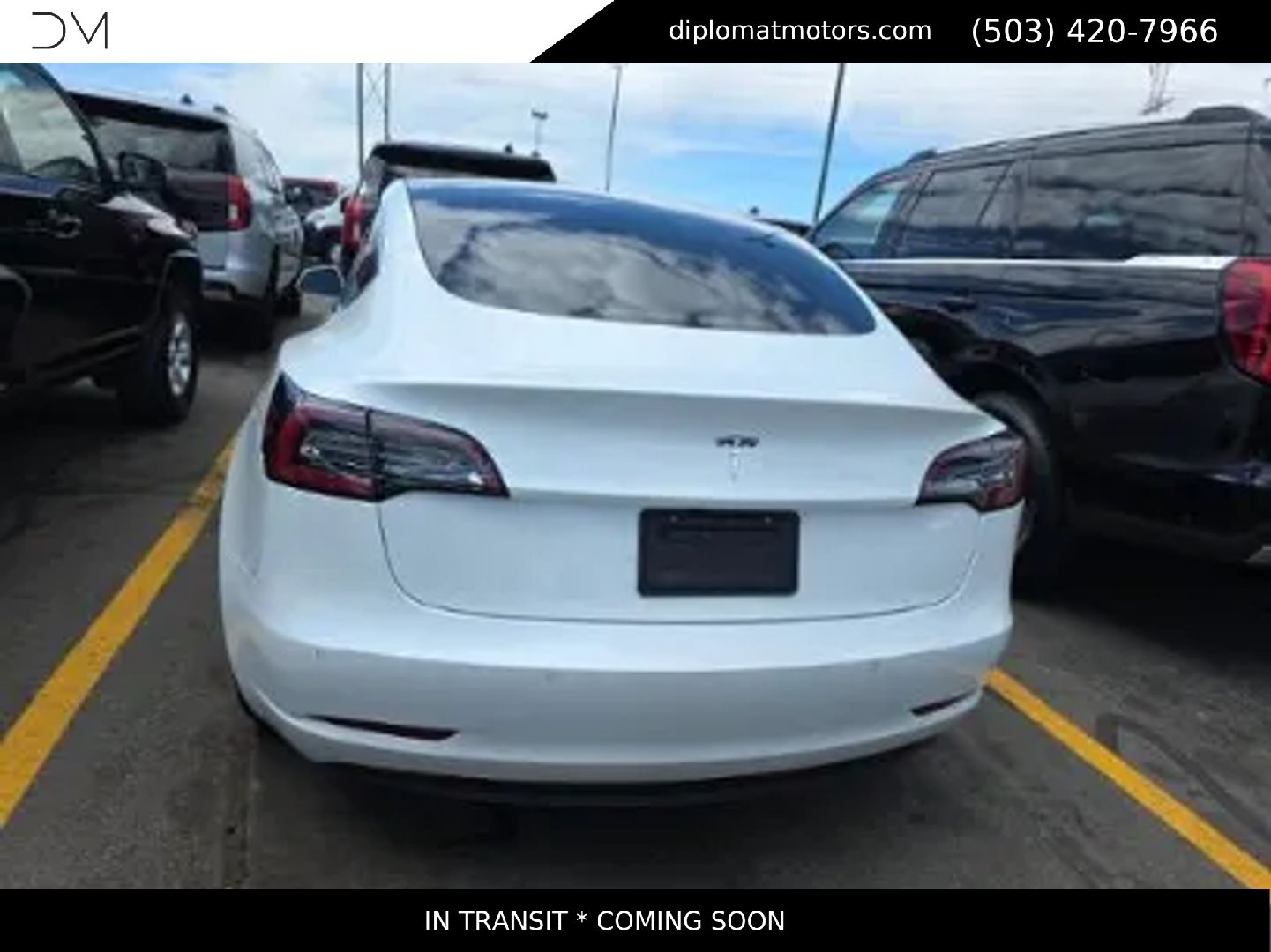 A white Tesla Model 3 parked at the Diplomat gallery