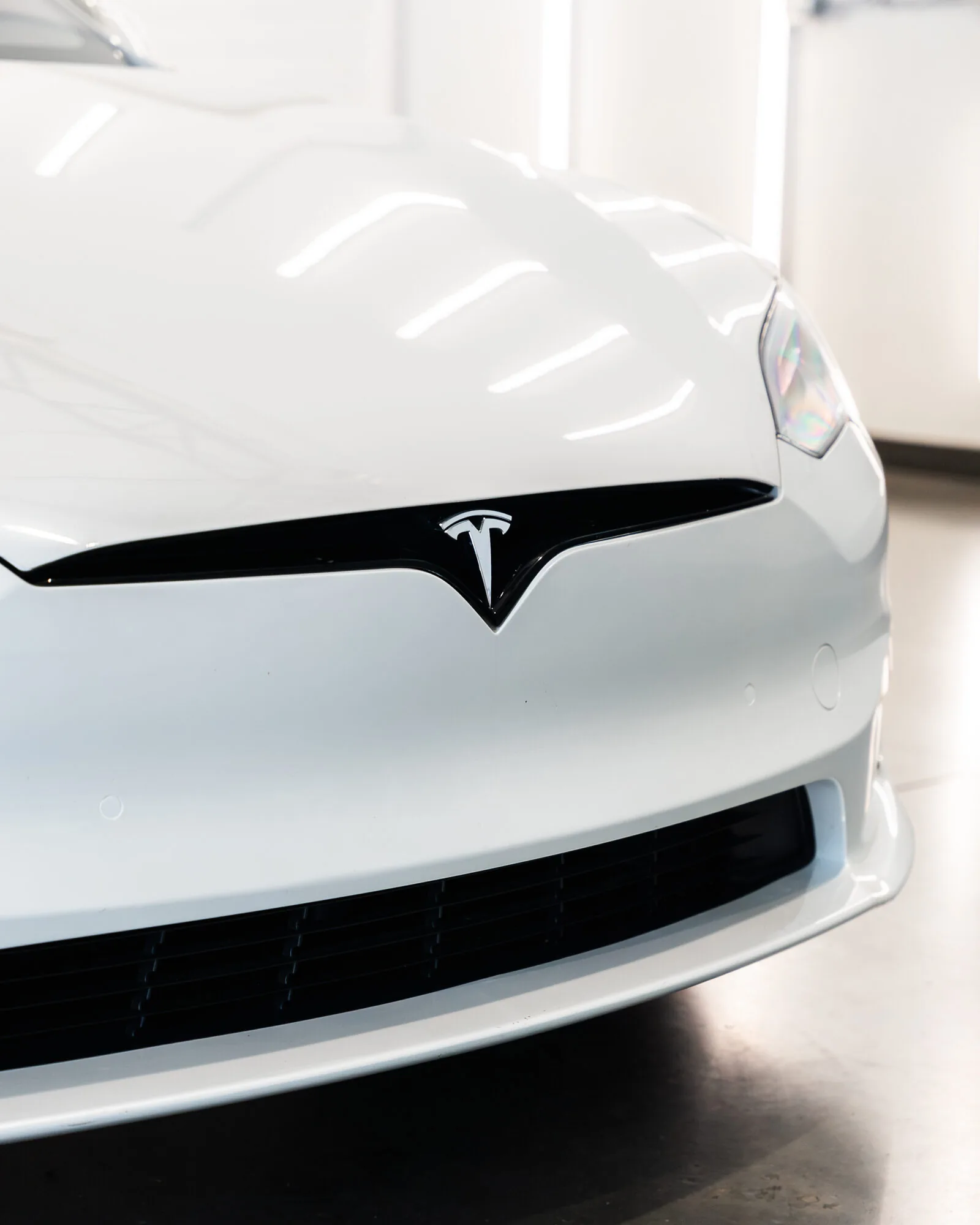The hood and badge of a Tesla up close