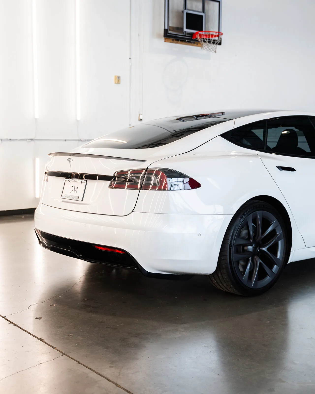 A white Tesla Model S wearing a Diplomat plate in the photo studio